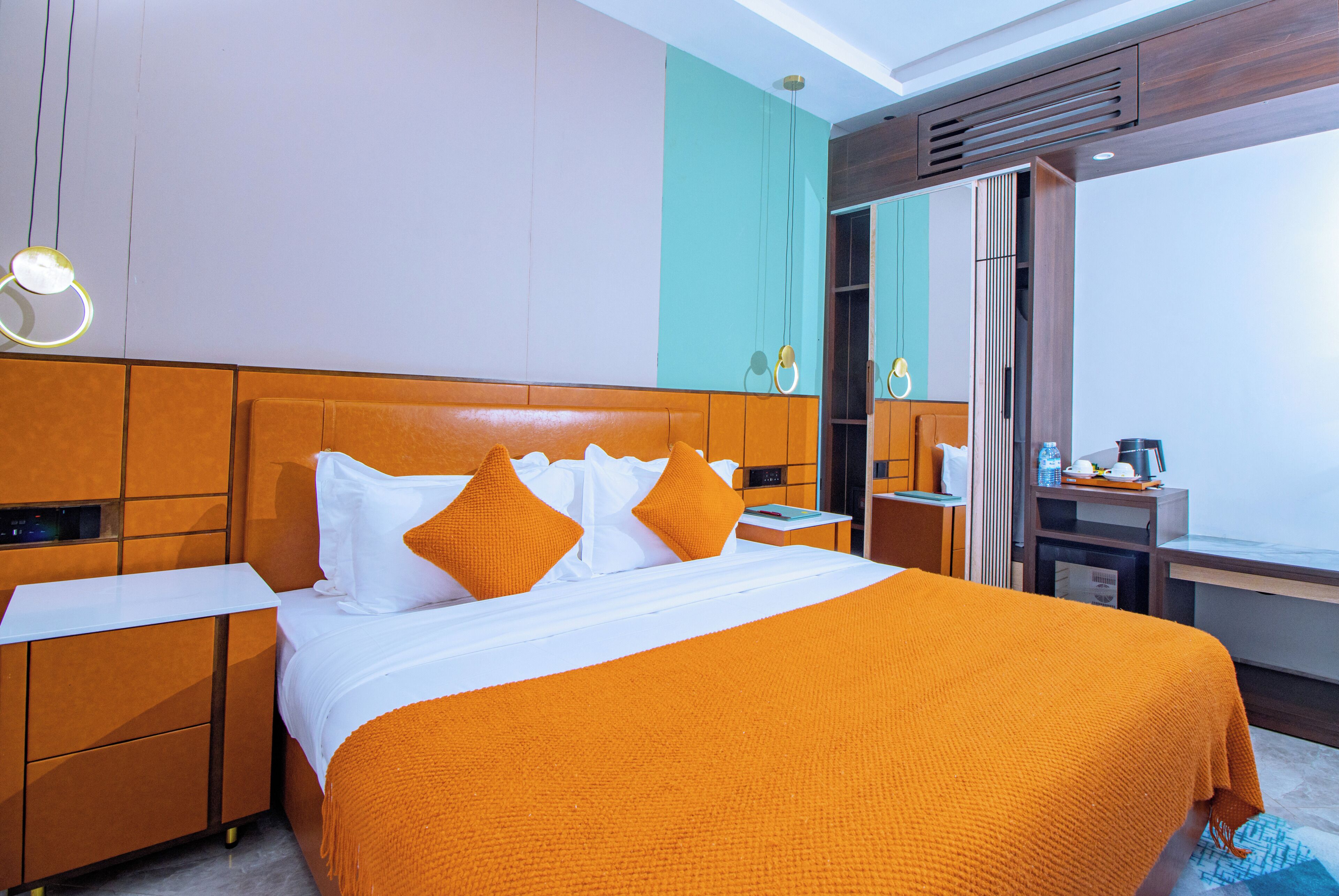 A hotel room with a large bed, a nightstand, a desk, and a window with a view.