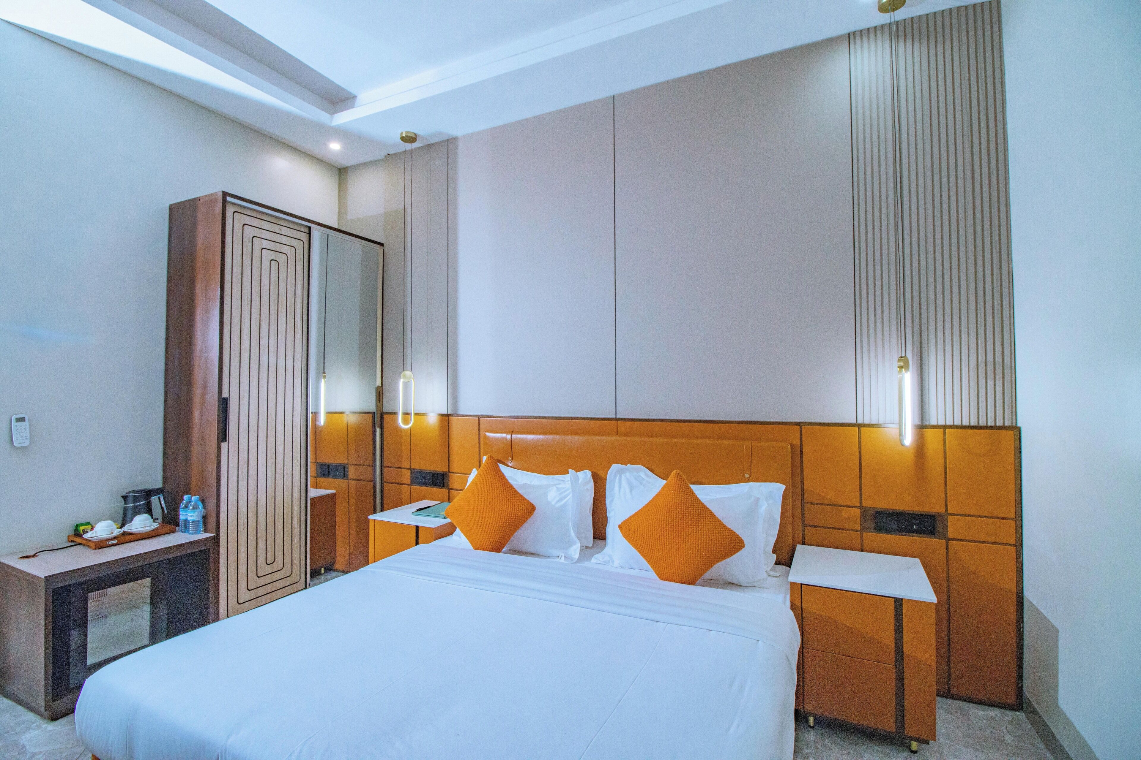 A hotel room with a bed, nightstands, a wardrobe, and a mirror.