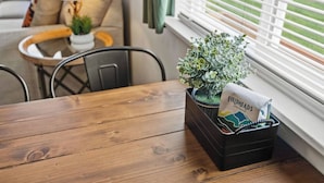 A dining table with a black tray containing a plant and a coffee roasting bag.