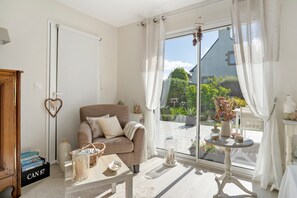 Una sala de estar acogedora con un sofá, una mesa de centro y vistas al exterior.