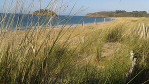 A coastal landscape with grassy dunes, a sandy beach, and a clear view of the sea. - Rêves d'Emeraude – Le Rêve du Pêcheur Guest Room (Cancale)