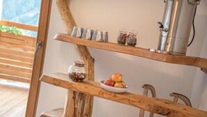 A wooden shelf with a bowl of fruit and a glass jar of nuts, a metal coffee maker, and decorative items on a wall. - Apartment "Wohnung Rosengarten Wieserhof" with Mountain View, Shared Garden & Wi-Fi (Aica di Sopra)
