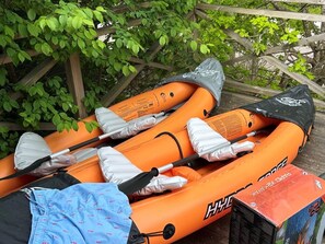 An orange inflatable raft with a paddle, a black bag, and a blue patterned cloth. - 4 Star Holiday Home in Trollhattan (Trollhattan)