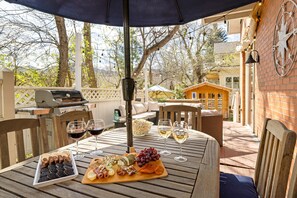 An outdoor dining area with a table set for a meal, surrounded by chairs and a grill. - Historic Family-Friendly Gem Steps from Downtown, CU & Hiking Trails (Boulder)