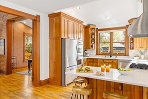 A kitchen with wooden cabinets, a refrigerator, a stove, and a sink. - Historic Family-Friendly Gem Steps from Downtown, CU & Hiking Trails (Boulder)