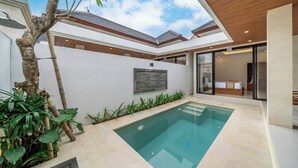 Una casa moderna con piscina, un árbol y vista al cielo.