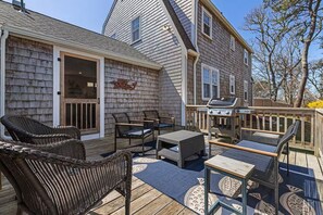 A deck with wicker furniture, a grill, and a house with shingled exterior. - Spacious, 4-bedroom, Dogs ok, Minutes from Beaches! (Harwich)