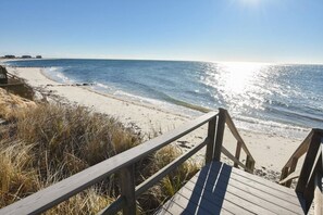 A wooden boardwalk leading to a beach with clear blue water and a distant shoreline. - Spacious, 4-bedroom, Dogs ok, Minutes from Beaches! (Harwich)