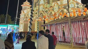 Un edifici ben il·luminat amb diverses cúpules i arcs, envoltat d'una multitud de persones.