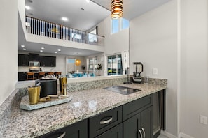 A modern kitchen with granite countertops, dark cabinetry, and a built-in microwave. - 6 mins to Disney • Game/Themed Rooms • Pool (Kissimmee)