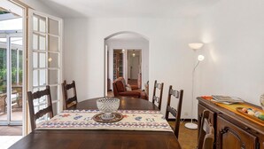 A dining area with a wooden table, chairs, a decorative bowl, and a patterned table runner. - Holiday Home with Park, Private Pool, Wi-Fi, and Air Conditioning in Jaujac (Jaujac)