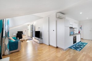Un apartamento moderno con habitación tipo loft, kitchenette y sala de estar.