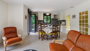 En moderne stue med spiseområde, sofa og fjernsyn.