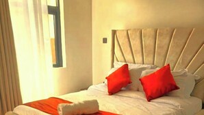 A bed with a headboard, a red throw blanket, and two red pillows. - Cozy 1-bedroom bed & breakfast in peaceful Nairobi,perfect for Relaxation &Work (Nairobi)