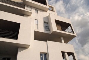 Un edificio a più piani con balconi, finestre e cielo sereno.