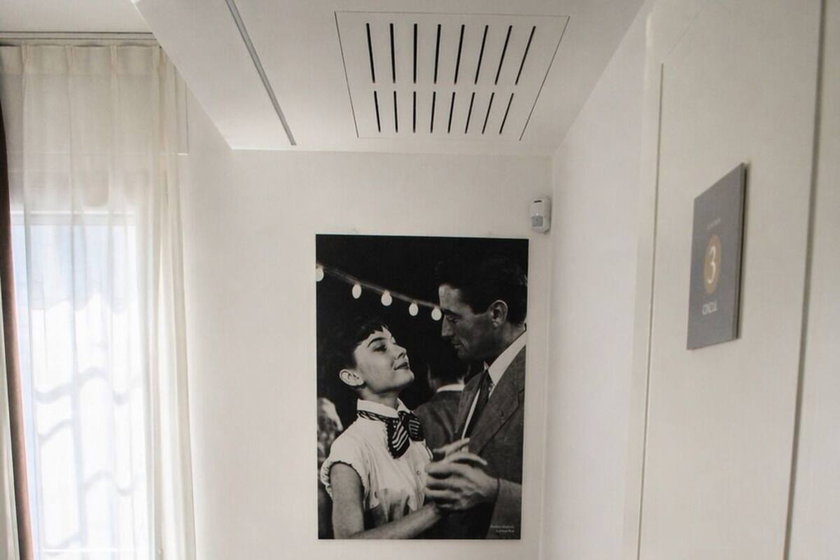 A small, well-lit room with a desk, chair, and a poster on the wall.