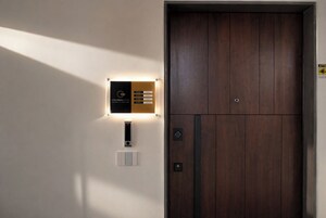 Ingresso di una camera d'albergo con una porta in legno, un lettore di badge digitale e una segnaletica che indica i tipi di camera.