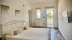 A bedroom with a bed, a radiator, and two windows. - B&B Helios (Nardò)