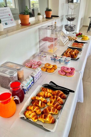 A buffet table with various food items including pastries, fruits, and dairy products. - B&B Helios (Nardò)