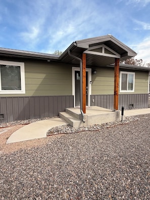A single-story building with a front porch, a door, and a window. - Your Home Away From Home
Quiet, Modern, & Open 1 (Delta)