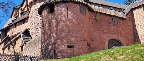 A historic stone building with a prominent tower and a small arched entrance.