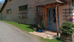 Une cabane en bois avec un toit en pente, une véranda et une porte.