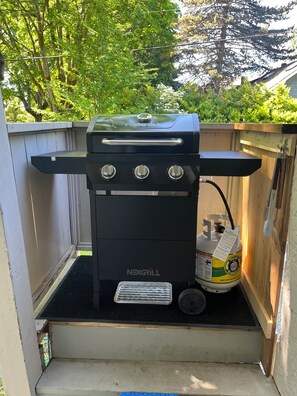 A black NEXGRILL barbecue grill with three burners, a gas tank, and a vented exhaust system. - Vancouver whole home stay with space for extended families & close to everything (Vancouver)