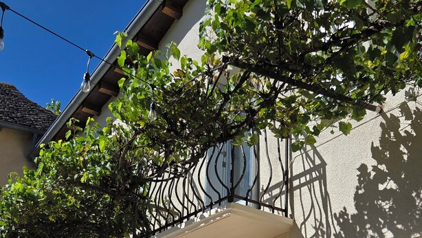 Ein Gebäude mit Balkon, Fenster und Wandleuchte.