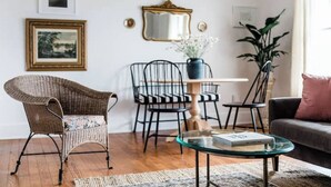 A living room with wicker furniture, a glass coffee table, a sofa, and a potted plant. - The Kenwick Pied-à-terre - Lexington Apartment with Historic Charm (Lexington)