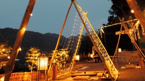 A swing set with lights, a wooden structure, and a clear sky. - SWAR Kasauli - Suites Cuisine Cave Club (Kasauli)