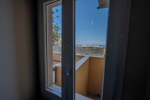 A window with a view of a balcony and buildings in the distance. - Suite Ionio - Teresita Guest House (Gallipoli)