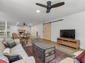 A modern living room with a sofa, a television, a wooden cabinet, and a fireplace.
