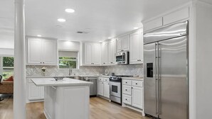 A modern kitchen with white cabinetry, stainless steel appliances, and a herringbone tile backsplash. - Perfect 3bedroom house in Colleyville, Proximity Sabre, Charles Schwab, Fidelity (Colleyville)