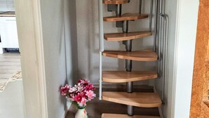 A spiral staircase with wooden steps and metal railings. - 4 Star Holiday Home in Bralanda (Bralanda)