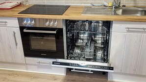 A kitchen with a built-in dishwasher, oven, and a wooden countertop. - 4 Star Holiday Home in Bralanda (Bralanda)