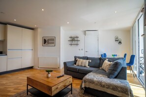 Ein modernes Wohnzimmer mit einer Couch, einem Couchtisch und einem Essbereich mit Stühlen.