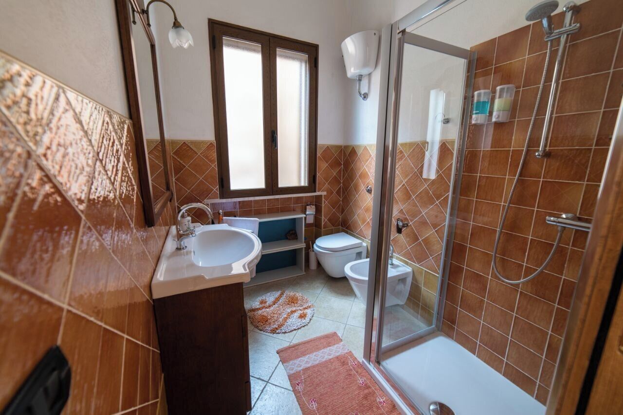Une salle de bain avec un lavabo, des toilettes et une douche.