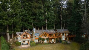 Un conjunto de cabañas de madera con base de piedra y un bosque circundante.