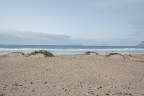 Una playa con arena, rocas y el océano.