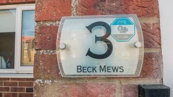 A house number sign with '3' and 'BECK MEWS' on a brick wall.