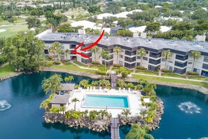 Ein Hotel mit Pool, umgeben von Grünflächen und einem Golfplatz, wie man es von oben sieht.