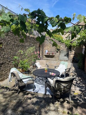 A patio with outdoor furniture, a stone wall, and a brick building in the background. - Cotswolds home gorgeous location (Nailsworth)