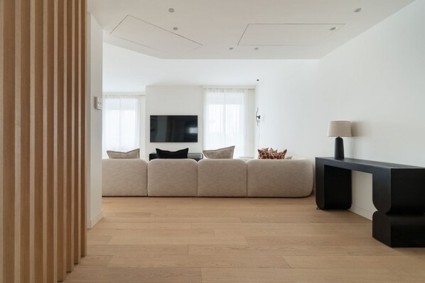 A modern living room with a sofa, a TV, and a lamp. - Modern and spacious 200m2 apartment, ideal for 6 people, located on the fifth floor of a building with lift.The accommodation is located in the San Siro area, a stone's throw from the famous San Siro Stadium and the Snai Hippodrome.The location is strate (Milan)