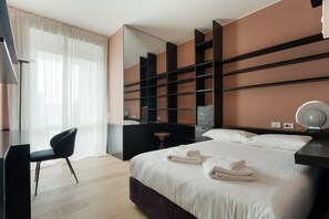A modern hotel room with a large bed, a desk, a chair, a mirror, and built-in shelving. - Modern and spacious 200m2 apartment, ideal for 6 people, located on the fifth floor of a building with lift.The accommodation is located in the San Siro area, a stone's throw from the famous San Siro Stadium and the Snai Hippodrome.The location is strate (Milan)