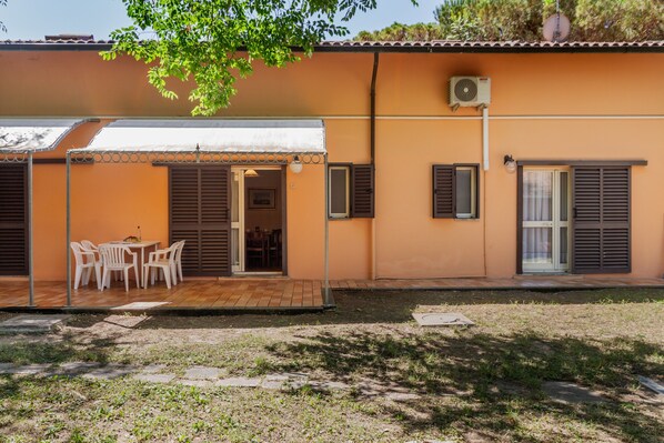 Un bâtiment doté d’un patio, d’un espace extérieur aménagé pour s’asseoir et d’une entrée couverte.