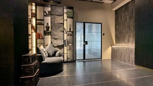 Ein modernes Interieur mit einer Couch, einer Steinwand und einer Schiebetür.