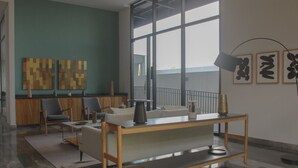 Un intérieur moderne avec une table en bois, des chaises, un canapé et des œuvres d’art accrochées aux murs.