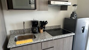 A kitchen with a microwave, stove, sink, and a blender on the counter. - Nuevo Depa Santa Ana 360 - 40 (Torre 11) (Zapopan)