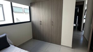 A bedroom with a bed, wardrobe, and a view through a window. - Nuevo Depa Santa Ana 360 - 40 (Torre 11) (Zapopan)