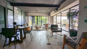 Een modern interieur met een eethoek, banken en een groot raam met uitzicht.